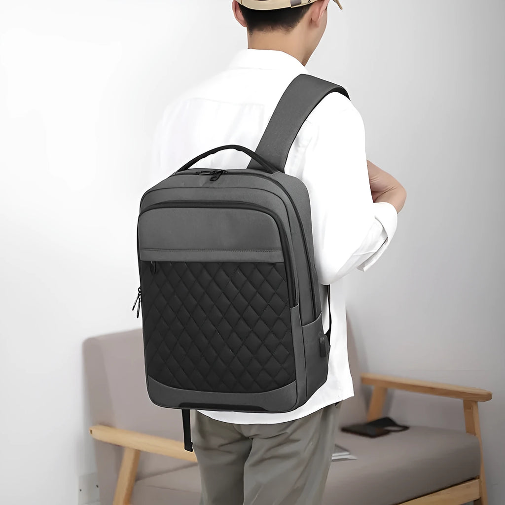 Men's solid colour Oxford cloth travel backpack with curved straps and diamond mesh detail, shown in grey.