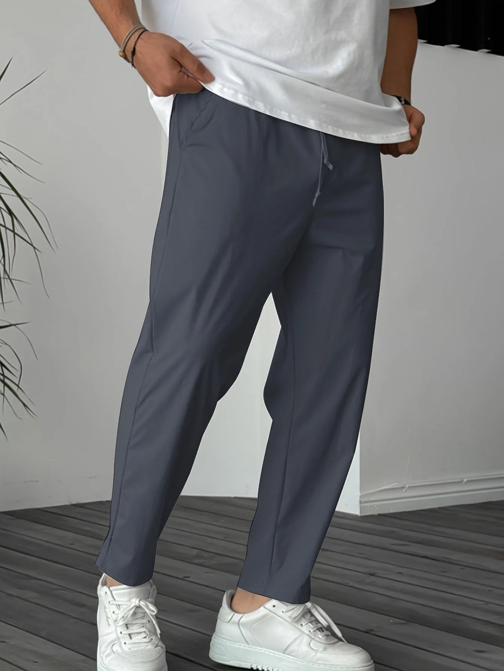 Man wearing khaki straight-leg drawstring trousers with a tonal ribbon pocket detail.
