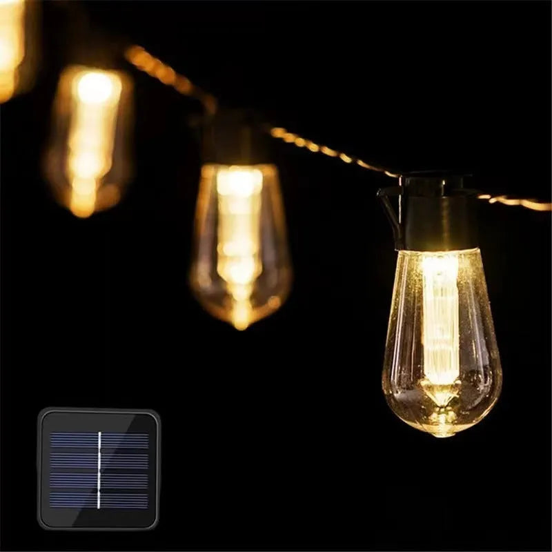 Retro infusion bottle shaped solar outdoor string lights draped in a garden setting.