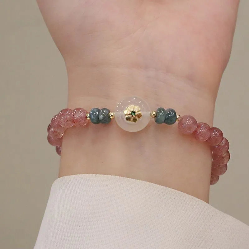 Women's strawberry quartz bracelet with blue water emerald jade pendant, geometric shapes, and traditional Chinese symbolism