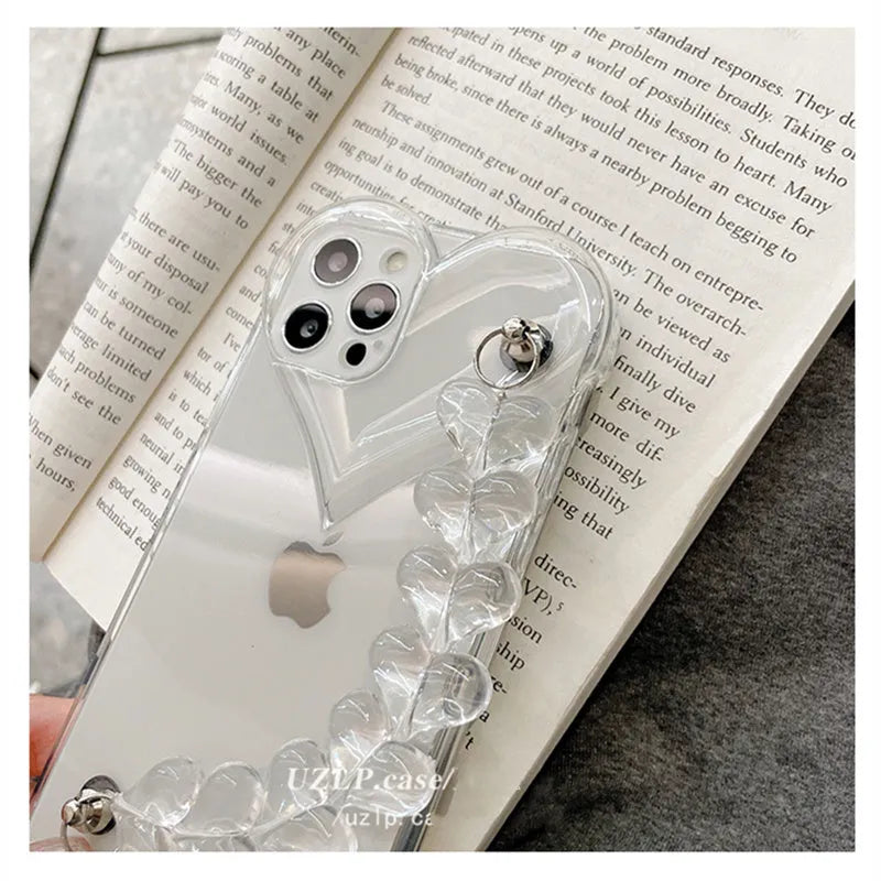 Transparent clear iPhone case with a love heart chain design on a smartphone.