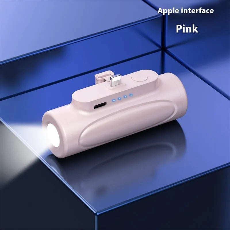 Black and pink portable power bank with a built-in LED flashlight, showing USB-C and Apple port options.