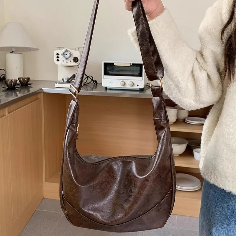 Female retro casual large capacity single shoulder crossbody bag in PU leather, brown, with sewing line detail and dumpling shape