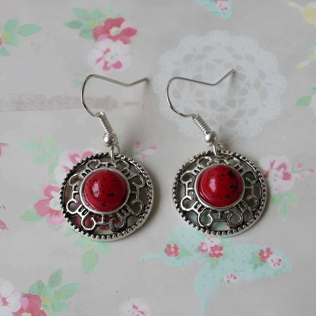 Handmade silver and turquoise ethnic earrings with geometric flower disk and traditional patterns.