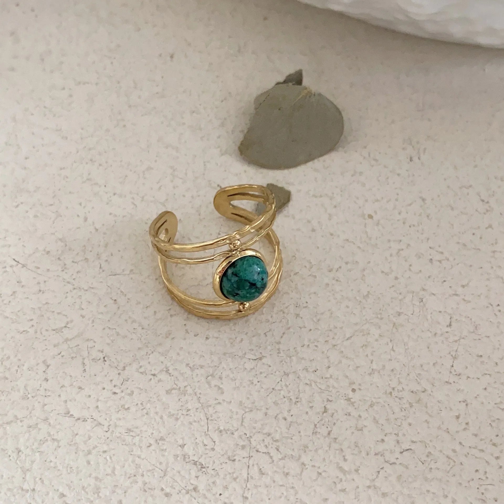 Geometric open ring made of titanium steel with a green natural stone.