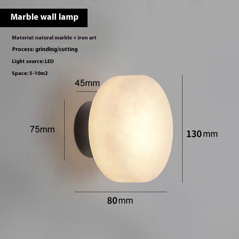 Spanish natural marble round wall lamp with warm light, 130mm diameter, black finish on a bedroom wall