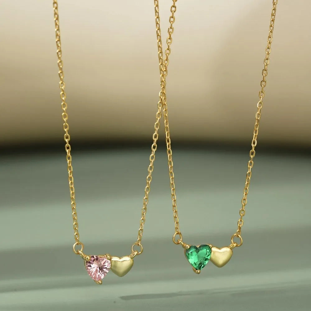 925 silver heart necklace with emerald zircon in gold finish on display