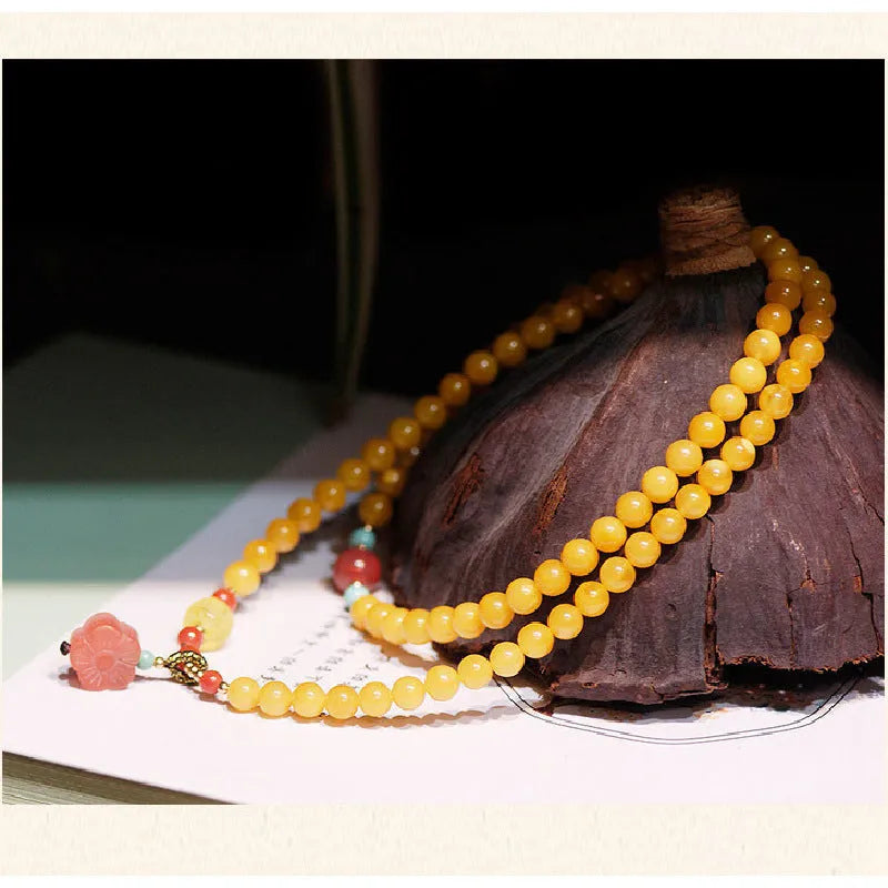 Yellow chicken grease beeswax amber bracelet with 5mm round beads and animal zodiac design.