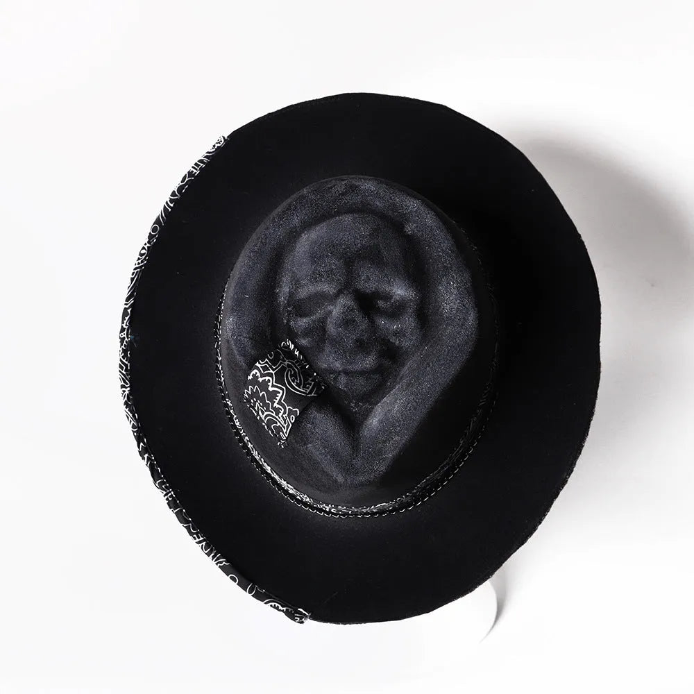 Handmade wool felt skull hat with a pointed conical crown on a neutral background.