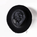 Handmade wool felt skull hat with a pointed conical crown on a neutral background.