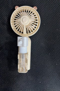 Compact plastic USB rechargeable nozzle fan in a choice of five colours on a desk.