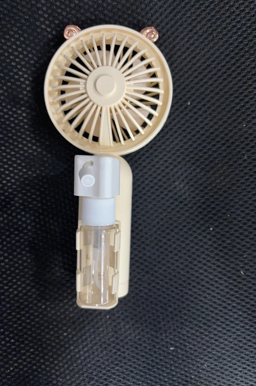 Compact plastic USB rechargeable nozzle fan in a choice of five colours on a desk.