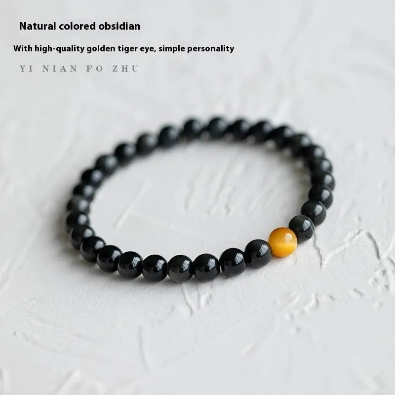 Black obsidian geometric bracelet with spherical beads on a wrist, showing unisex Korean style.