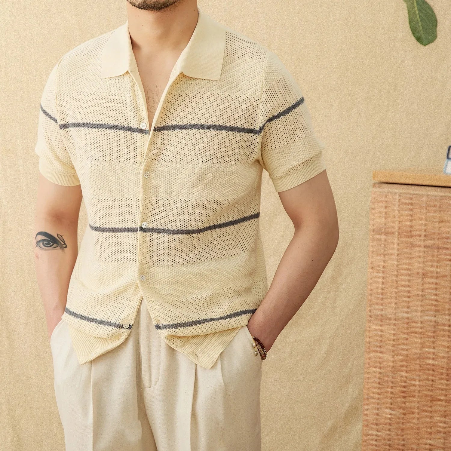 Men's camel coloured short sleeve knitted cardigan with a lapel collar on a hanger.
