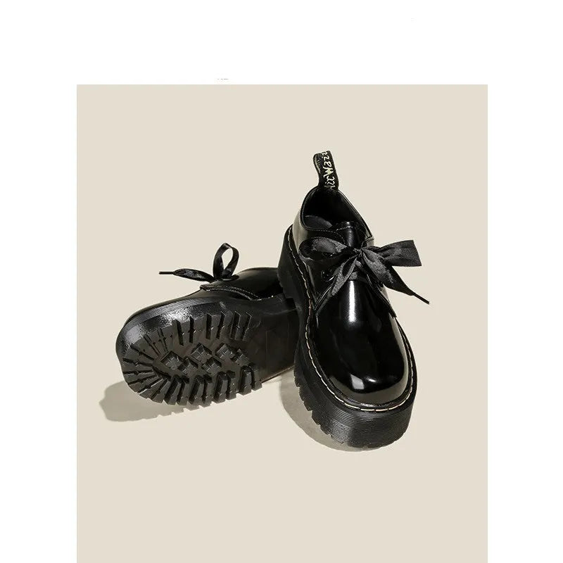 Black women's lace-up shoes with a thick sole, ribbon detail, and cross straps.