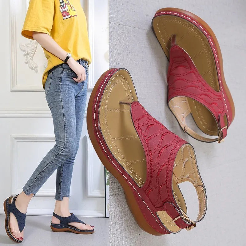 Women's red casual wedge heel sandals with an adjustable buckle strap on a white background.