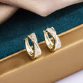 Geometric shaped women's earrings with 14K yellow gold plating and zircon stone details on a copper base.