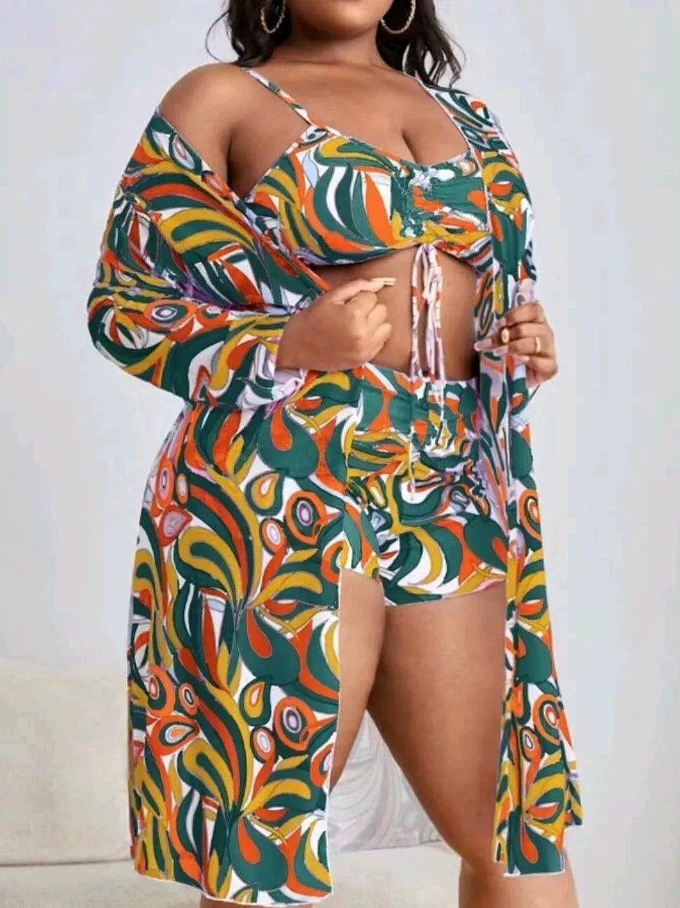 Women's floral print three-piece bikini set with cardigan on a mannequin.