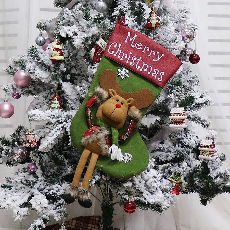 Three large Christmas stockings with 3D Santa, snowman, and reindeer designs hung on tree