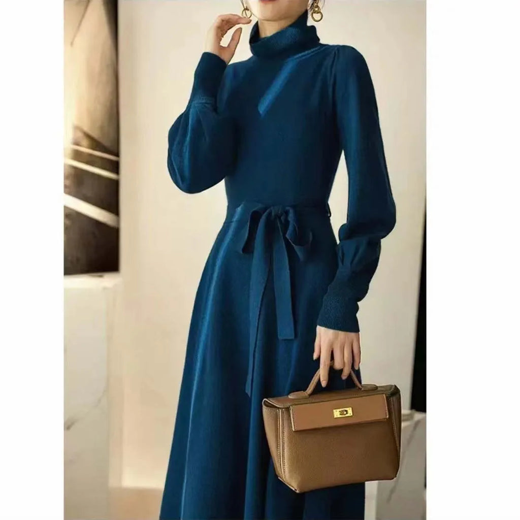 Rose red loose turtleneck knit dress with long sleeves and a flared skirt hem on a hanger.