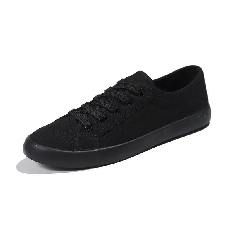 All black women's canvas lace-up work shoes with flat rubber soles.