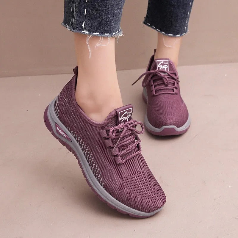 Women's low-top mesh sneakers in black, gray, or purple with round toe, cross straps, and rubber sole.