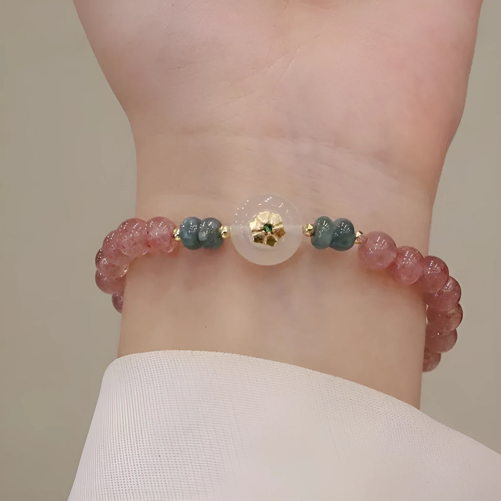 Women's strawberry quartz bracelet with blue water emerald jade pendant, geometric shapes, and traditional Chinese symbolism