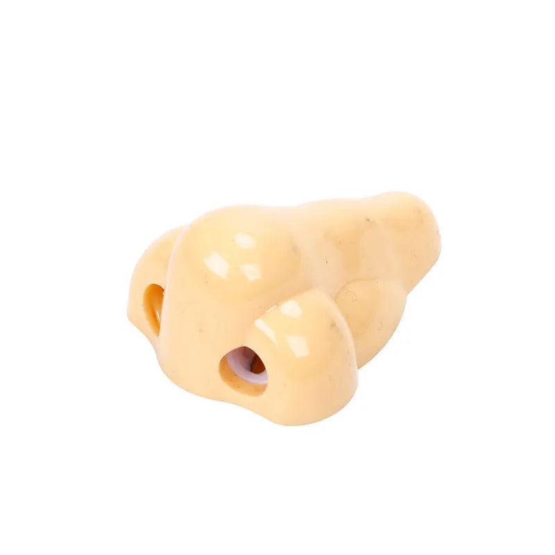 Flesh colour plastic manual pencil sharpener with big nostril hole on geometric body.