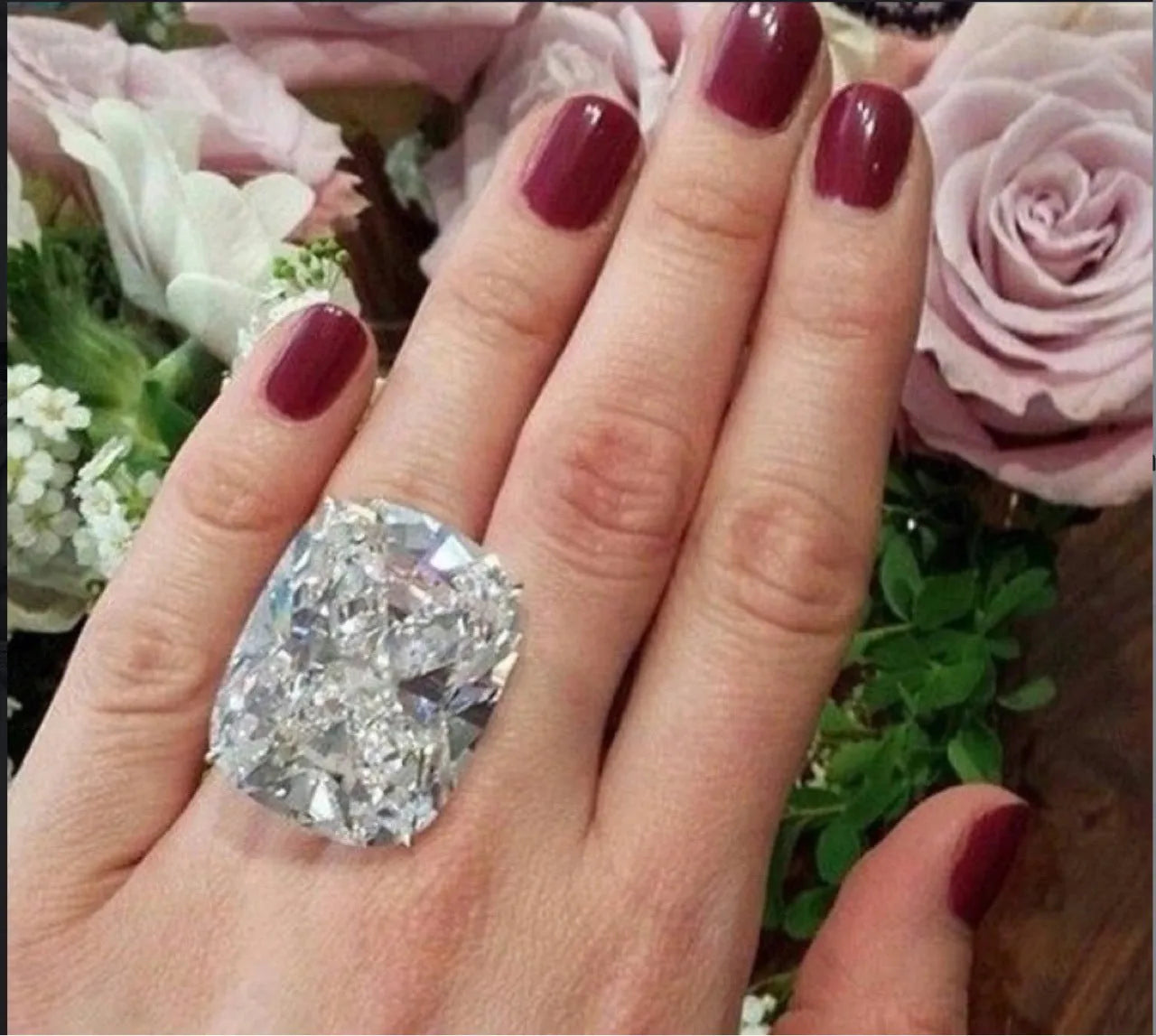 Women's white gold colour ring with a simple inlaid square diamond geometric design on a finger.
