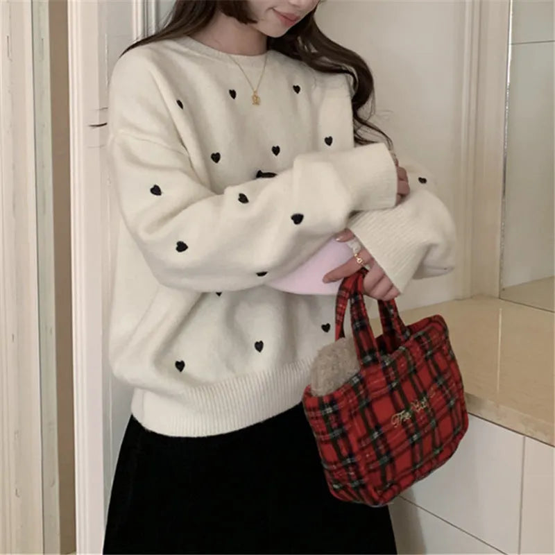 Women's loose cream embroidered acrylic pullover sweater with long sleeves, shown on a hanger.