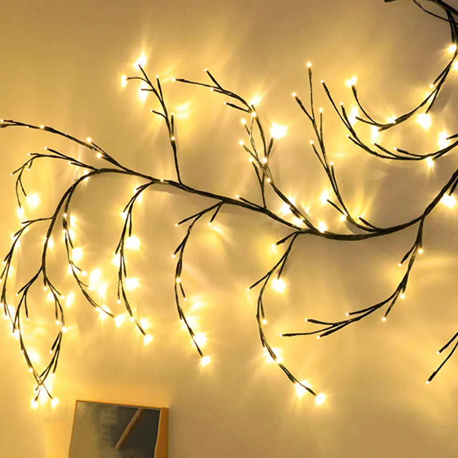 Flexible LED willow vine garland with warm white lights shaped into a decorative curve on a wall.