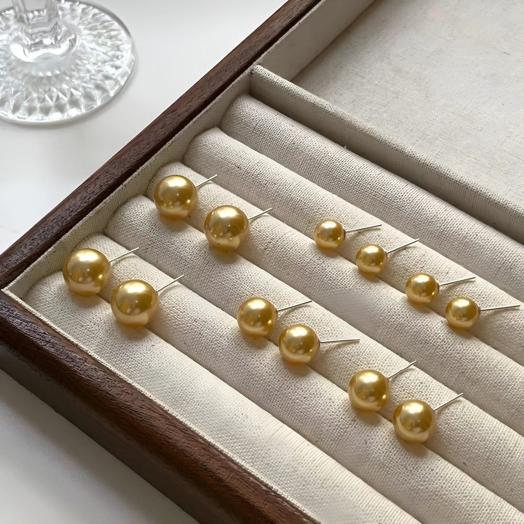 Pearl stud earrings with geometric star design in silver, showing size options from 8mm to 14mm diameters