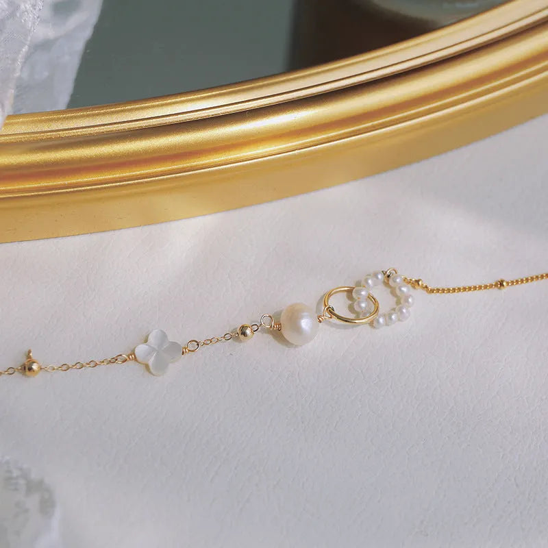 Close-up of a women's natural pearl bracelet with 14k gold-plated metal detailing.