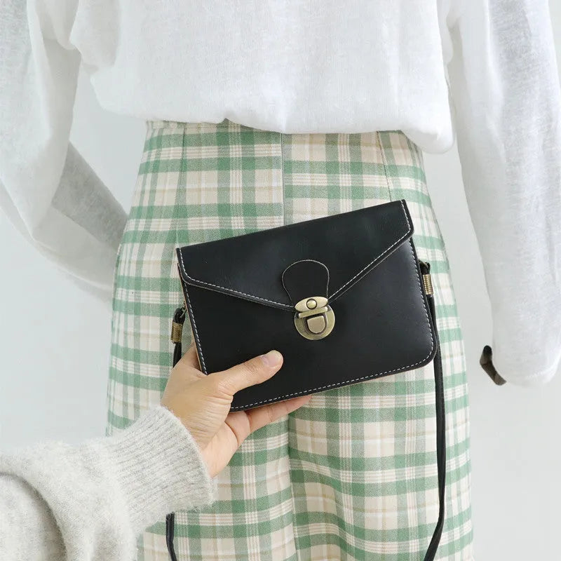Soft surface crossbody messenger bag with flap closure and lock hardware in wine red colour