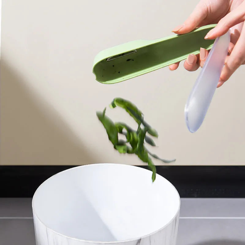 Dark green potato peeler with a removable storage tube and a stainless steel blade.
