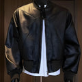 Men's long black slim-fit PU leather jacket with litchi grain texture on a hanger.