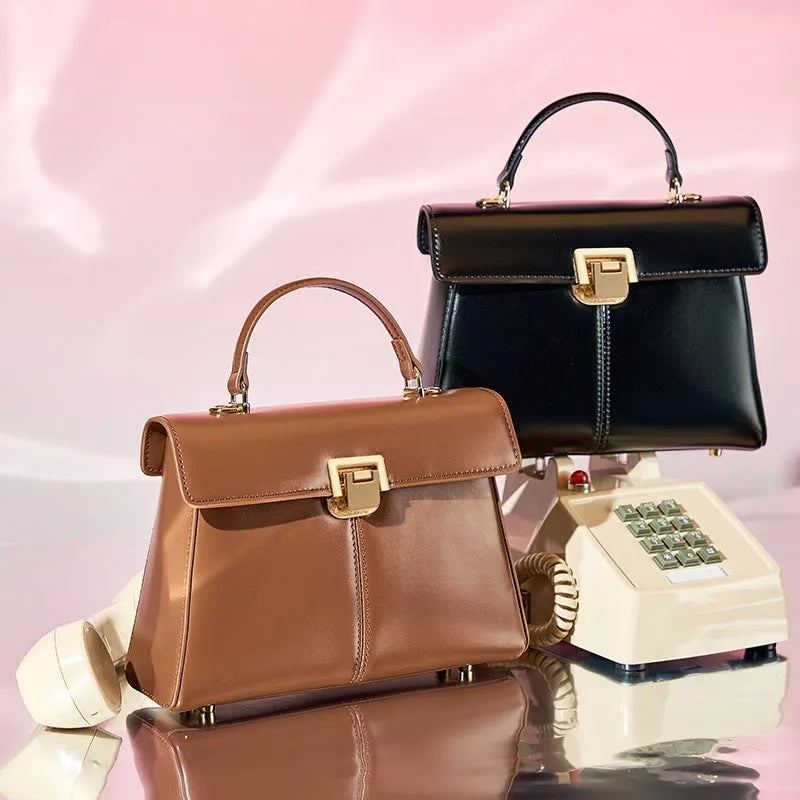 Black genuine leather women's shoulder bag with clasp closure and adjustable strap.