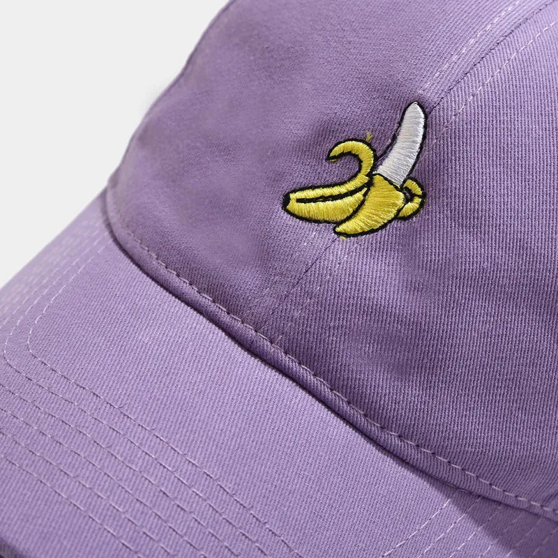 Adjustable black baseball cap with white banana embroidery on the front.
