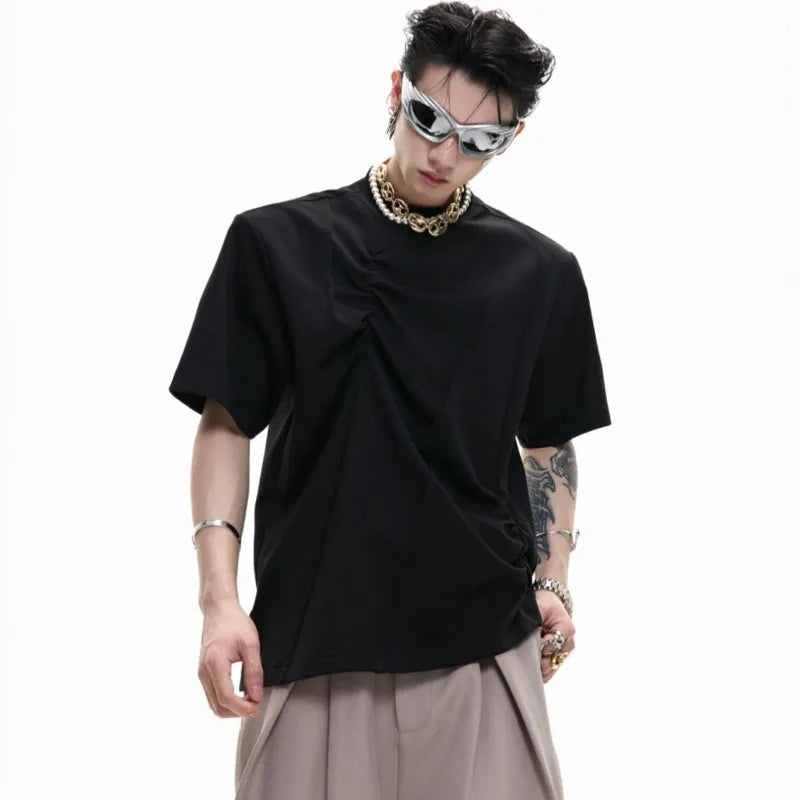 Men's loose black cotton T-shirt with textured pleats and asymmetric design detail.