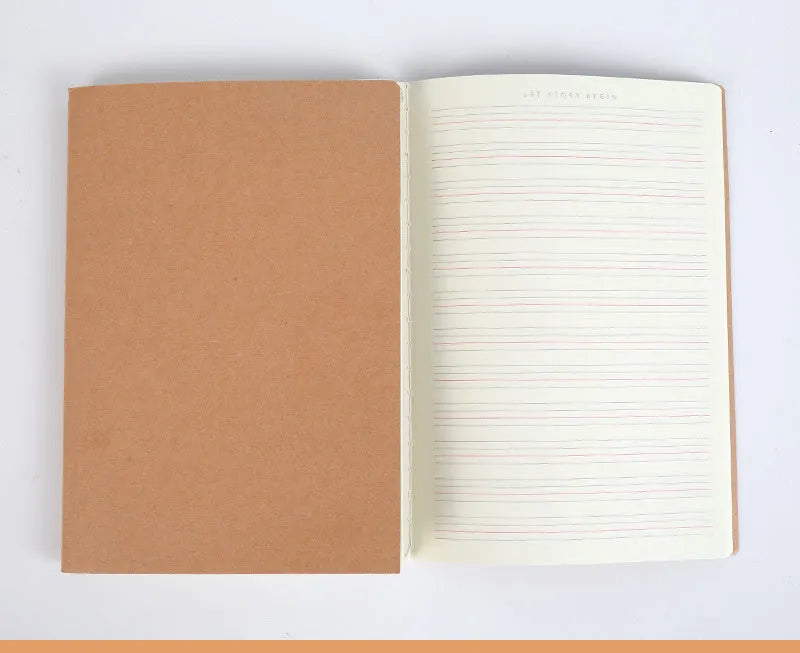 Beige softcover thread-bound notebook in 16K size lying open on a table, showing grid paper inside.
