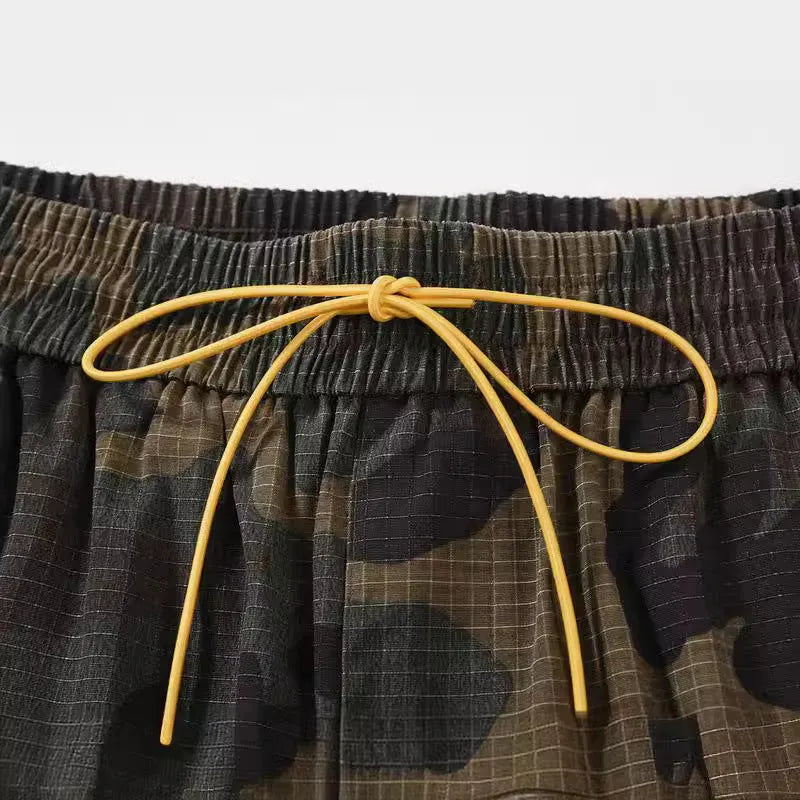 Man's green H215 camouflage cotton work shorts with multiple pockets shown in a loose fit.