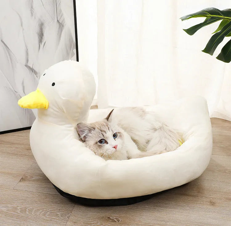 Blue duck-shaped fluffy pet bed for small dogs and cats on a wooden floor.