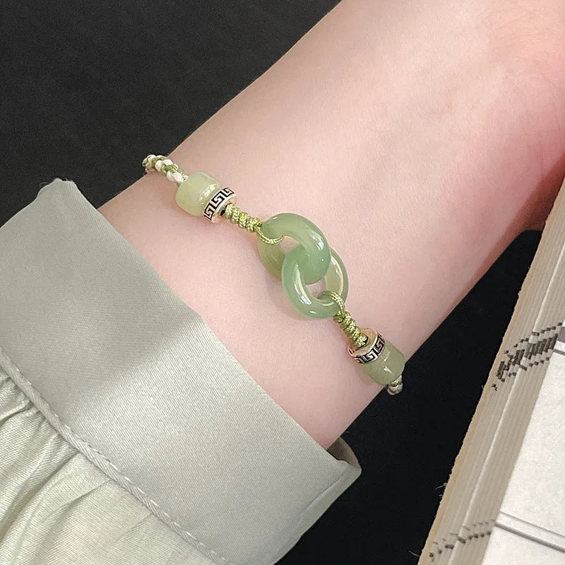 Green adjustable bracelet with jade peace buckle and copper zodiac charm.