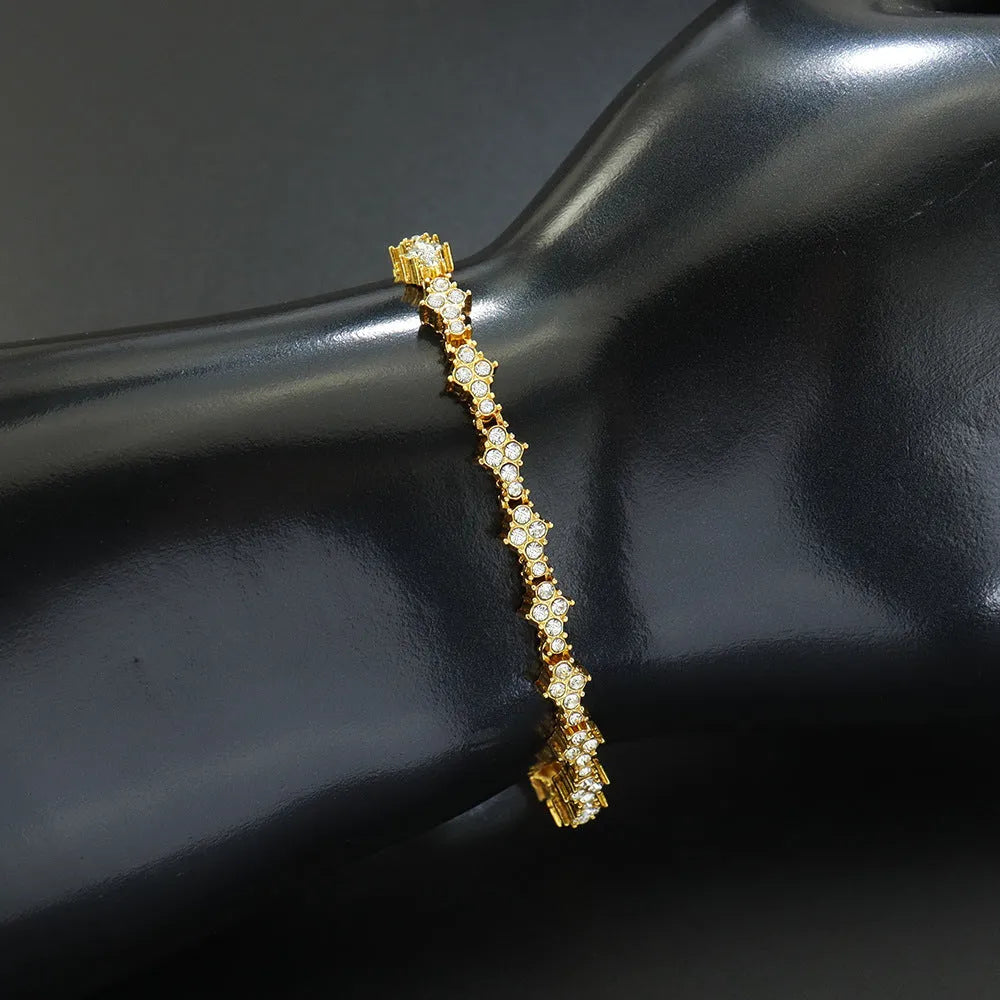 Flower-shaped cross tennis chain bracelet in gold alloy with diamond geometry pattern close-up