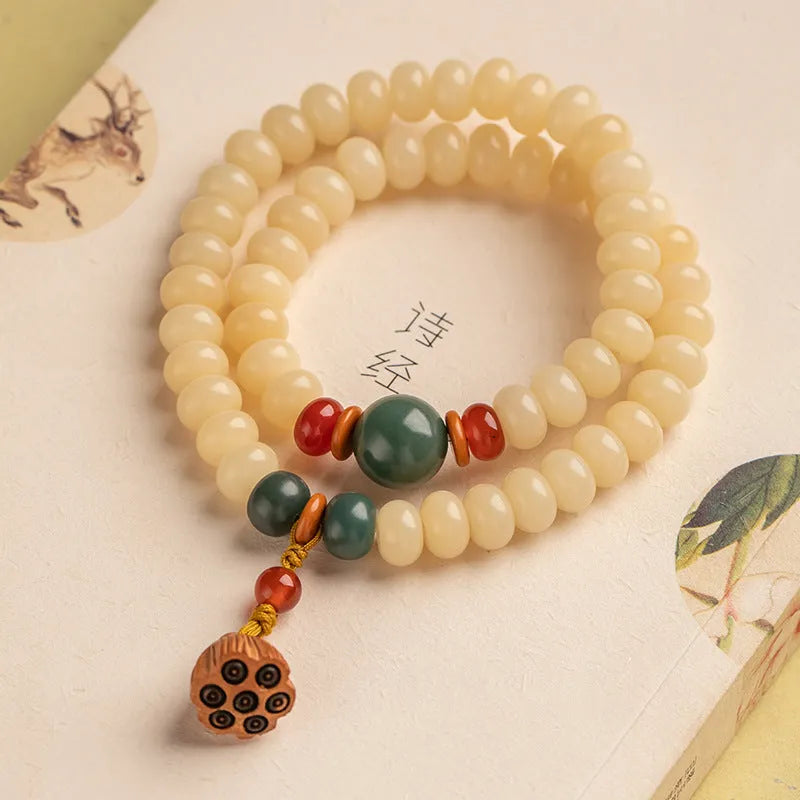 Cream topaz coloured wooden Bodhi root bracelet with flat round beads on a wrist.