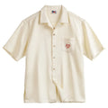 Light apricot men's shirt with bamboo pattern and Cuban collar shown on hanger