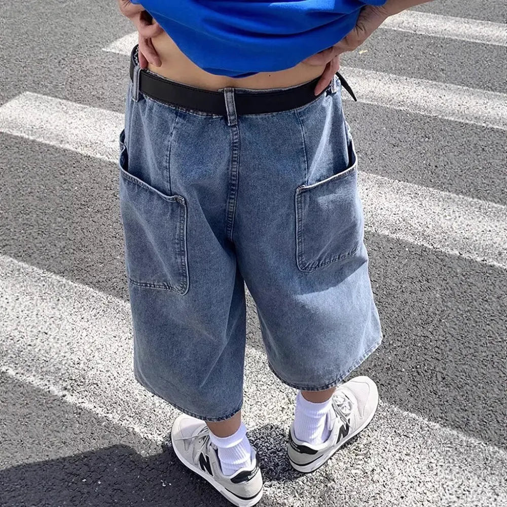 Men's blue washed denim cropped shorts with a high waist and zipper fly on a neutral background