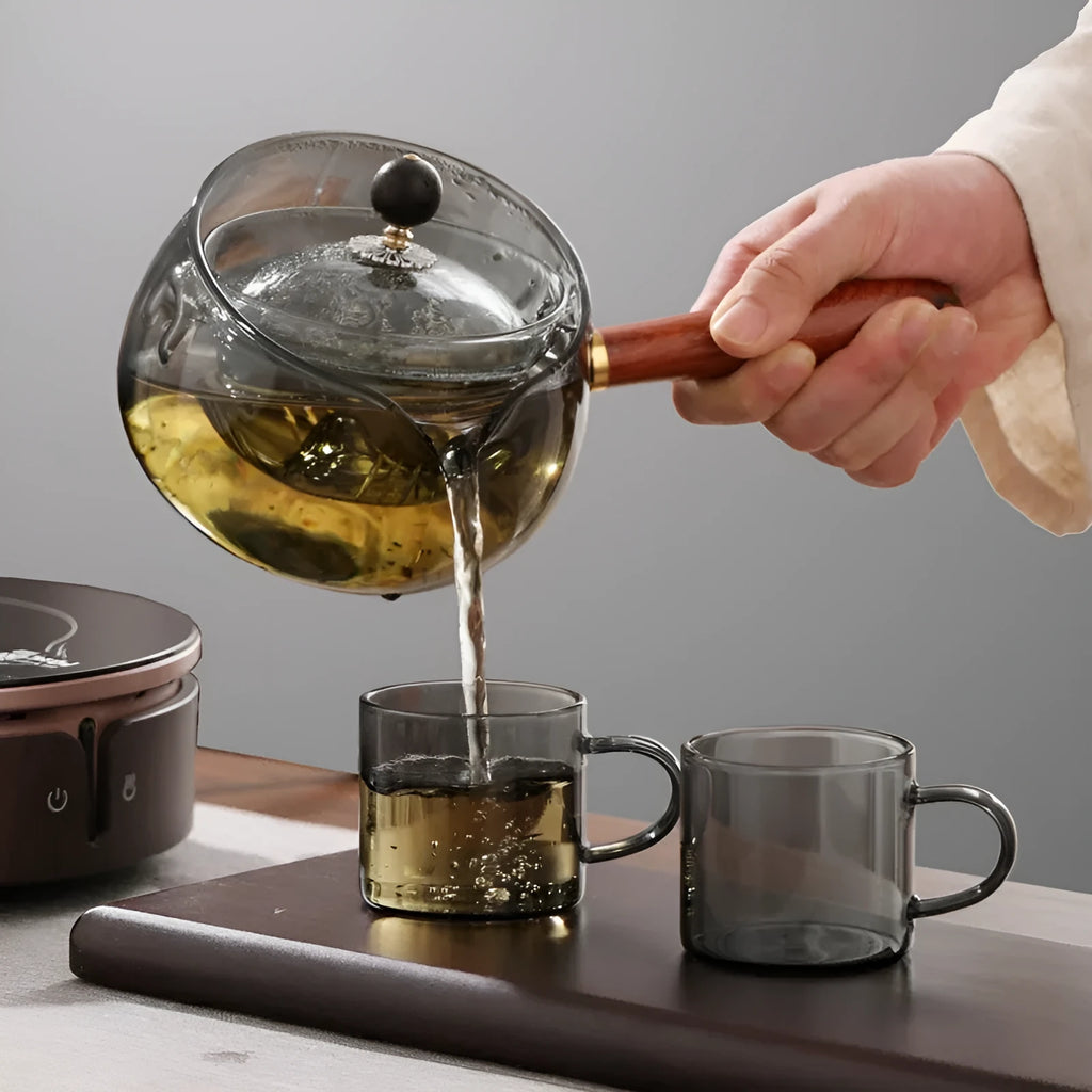 Transparent rotating glass teapot with wooden handle and integrated tea infuser