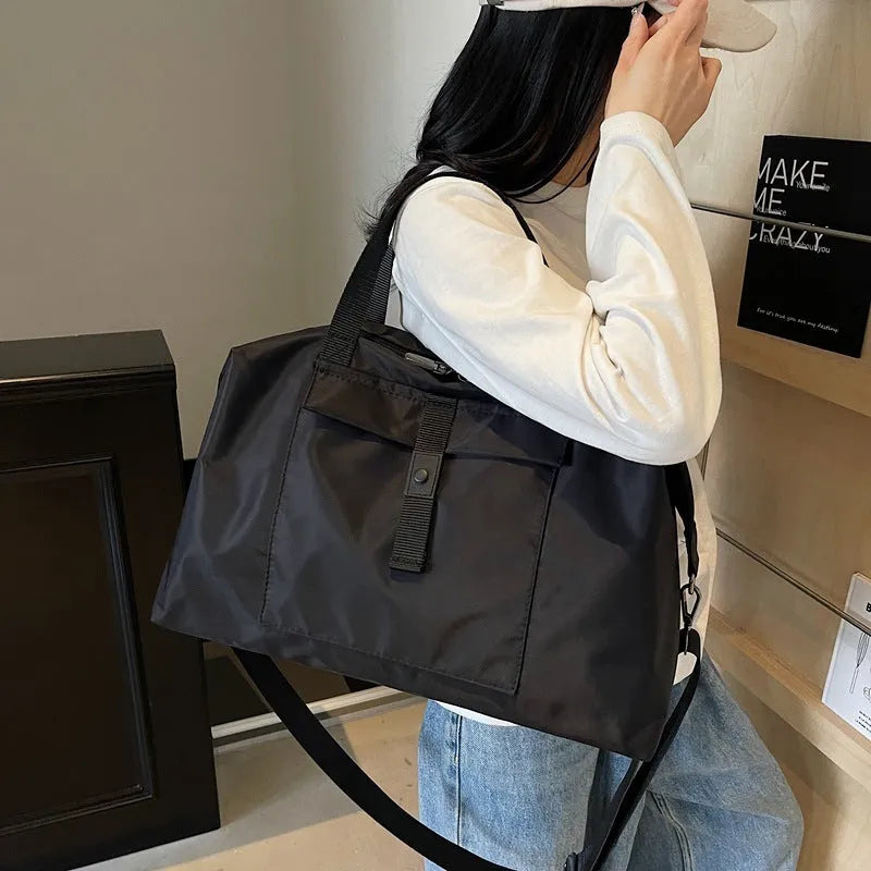Grey one-shoulder travel bag made from Oxford cloth with a large capacity.