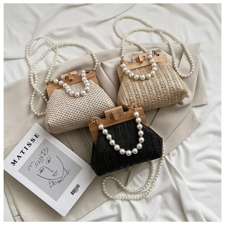 Women's woven straw shoulder bag with pearl chain strap in beige, showing internal organiser pockets.